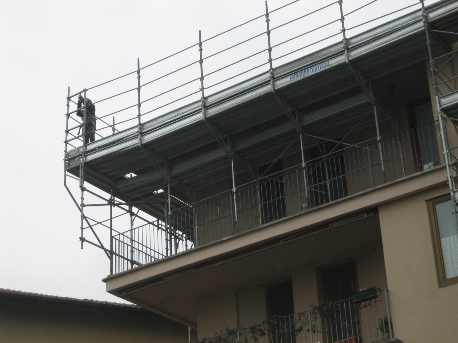 Operatore Lamanna Ponteggi in quota su impalcato con parapetti a norma