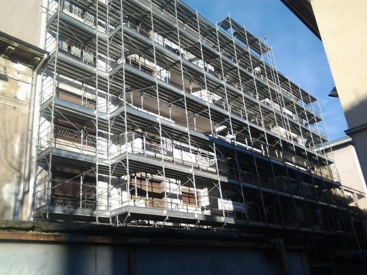 Ponteggio di facciata su edificio multipiano — vista dal basso del castello di telai.