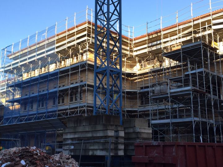 Grande cantiere di ristrutturazione: ponteggio multidirezionale e gru a torre.