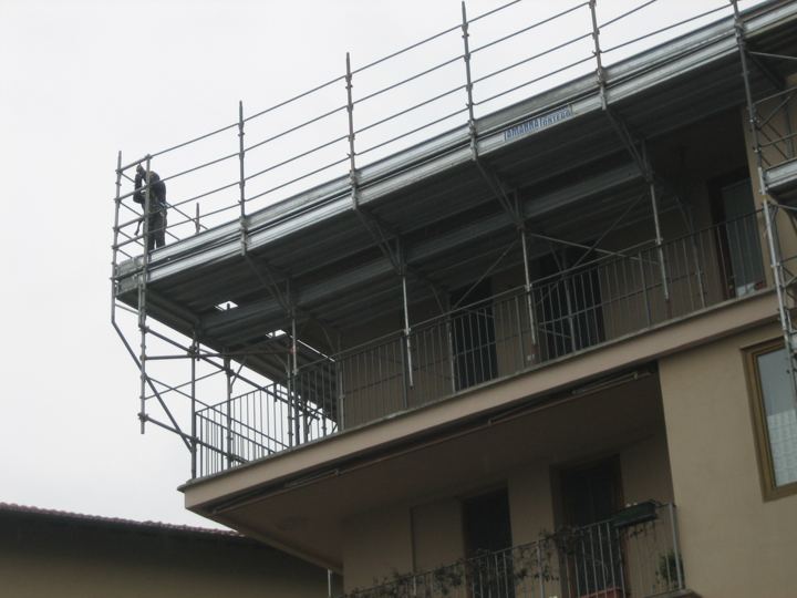 Operatore in quota su impalcato con parapetti a norma.