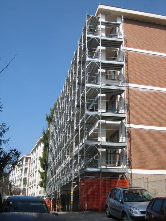 Edificio a torre in mattoni: ponteggio a tutta altezza.