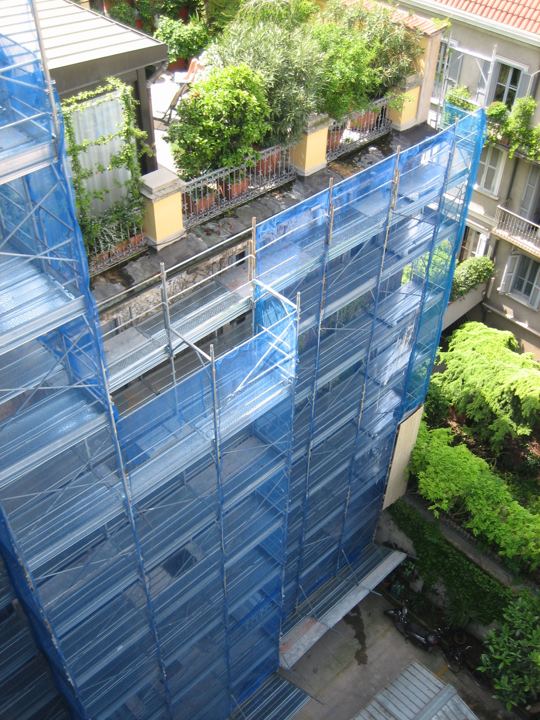 Ponteggio su corte interna con terrazzi verdi.