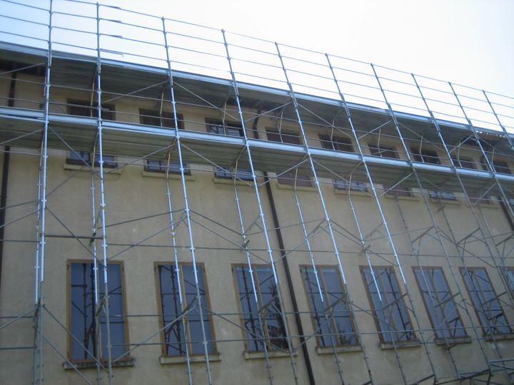 Dettaglio degli ancoraggi e delle diagonali su facciata con persiane.