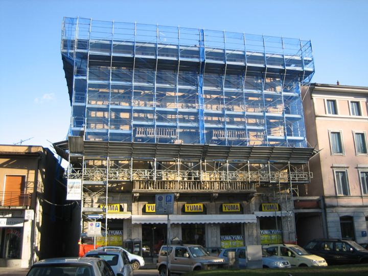 Edificio commerciale in centro storico: ponteggio sopra le attività aperte.
