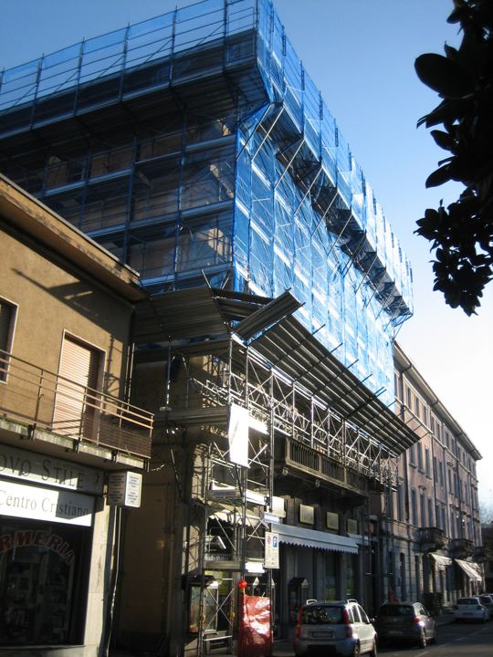 Fronte storico con rete blu su via del centro.